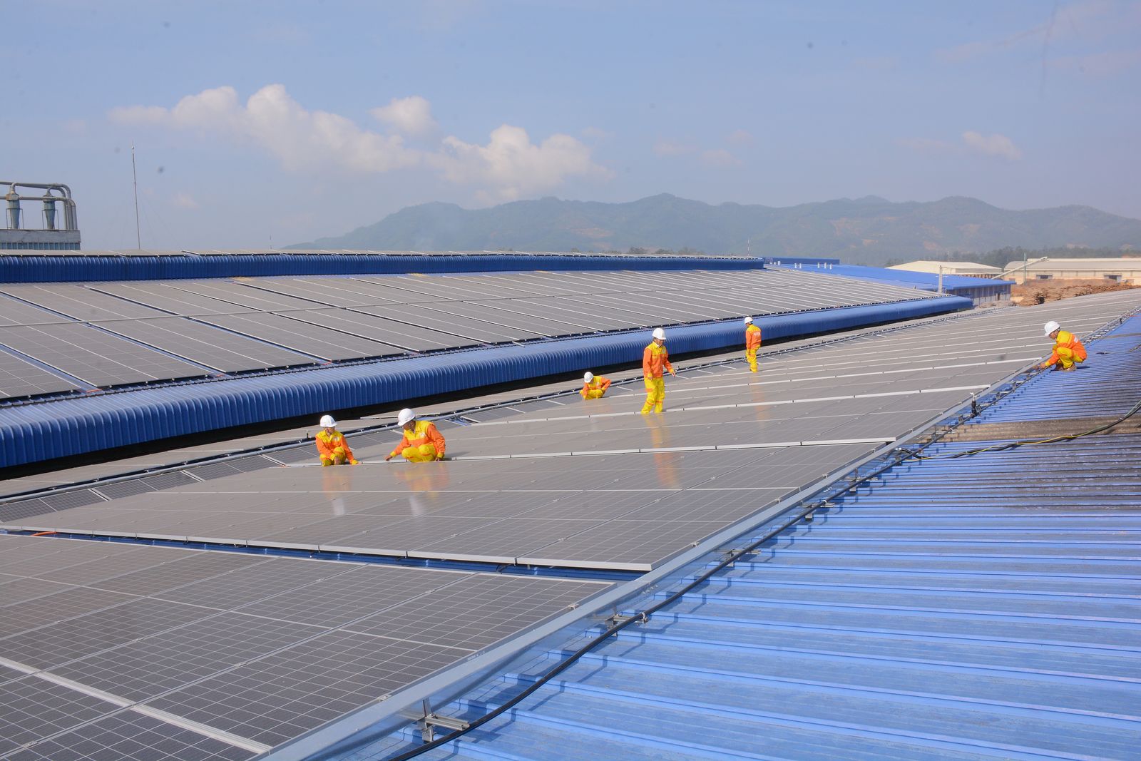 Minh họa cách lắp đặt điện mặt trời trên mái tôn: thợ lắp dàn pin trên mái tôn nhà xưởng