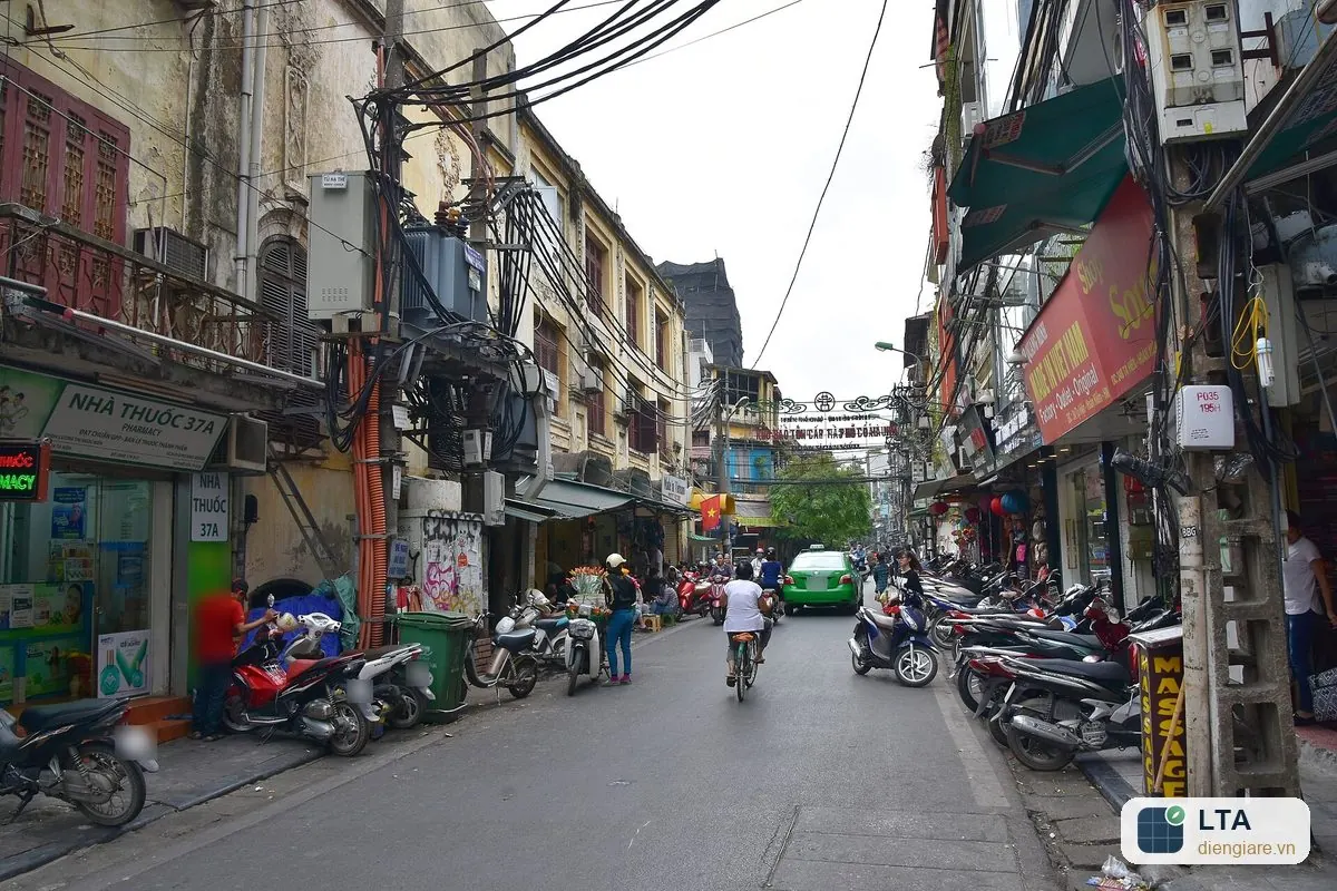 Dãy nhà ống ở phố cổ Hà Nội có cửa hàng ở tầng trệt, xe máy đỗ dọc vỉa hè